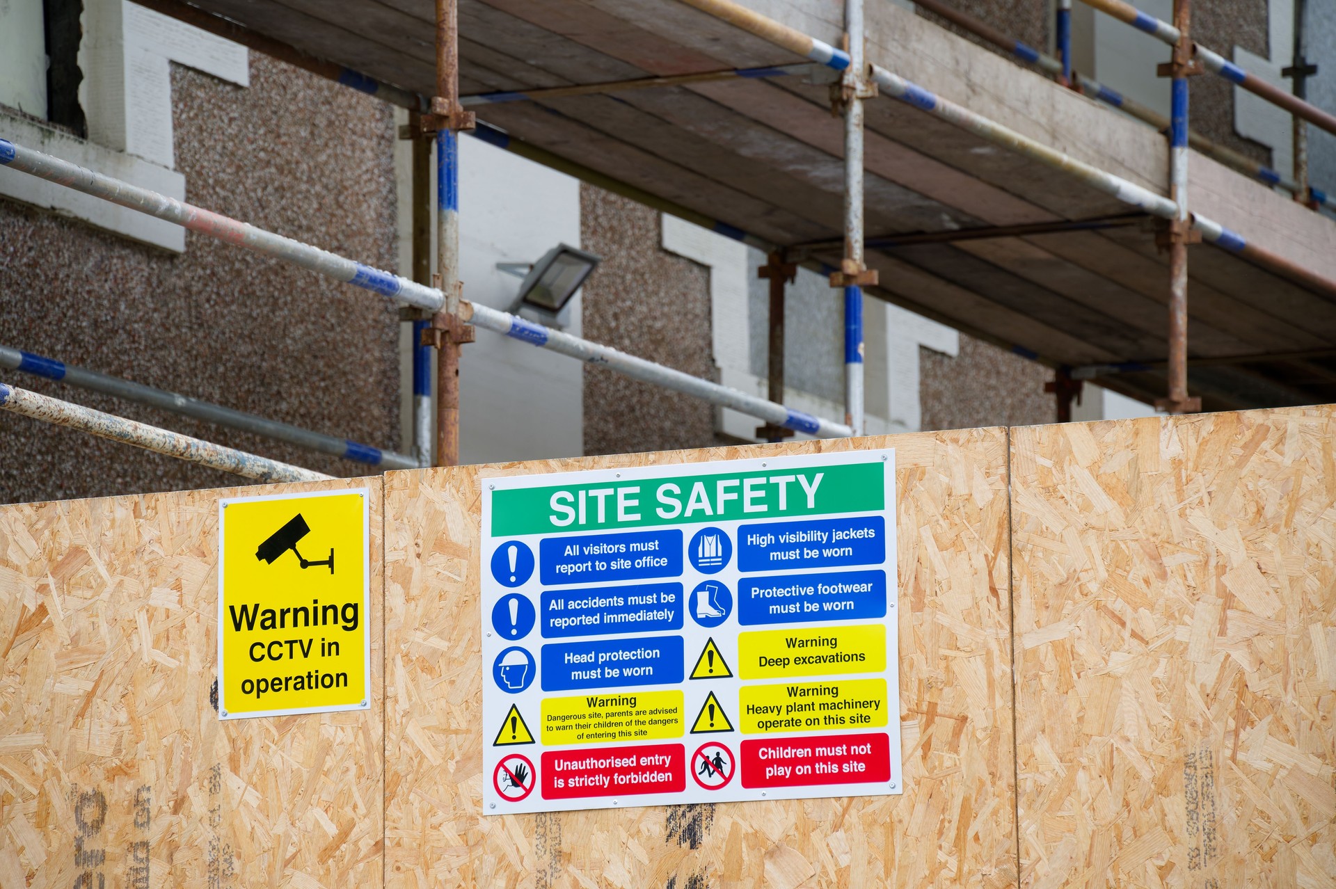 Construction site health and safety message rules sign board signage on fence boundary